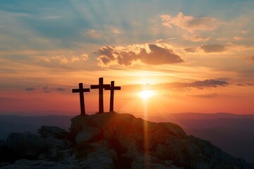 silhouette of three crosses on a rock, sunset on the background, easter concept  