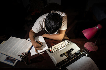 Un chico estudiando con su maquina de escribir 