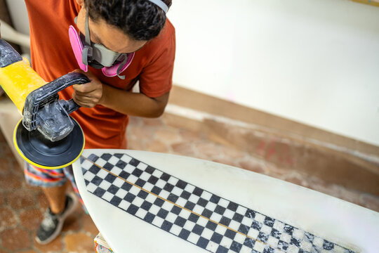 Male surfboard shaper at work in a workshop