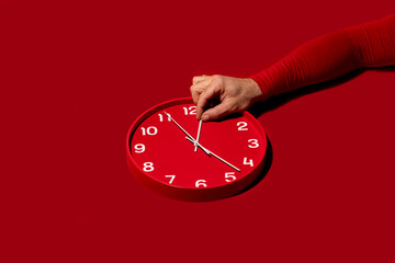 Adjusting time on a red wall clock