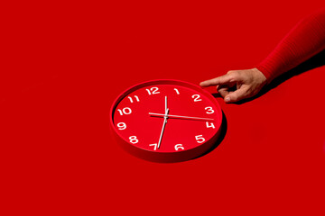 Pointing at Time: Hand Indicating a Red Clock
