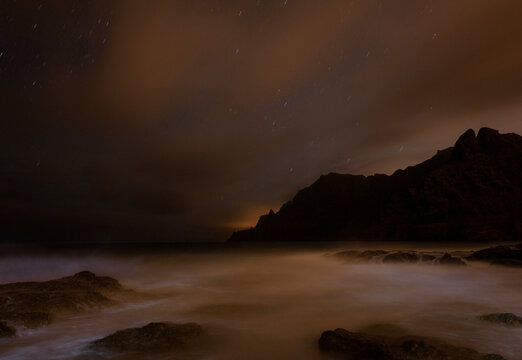 Serene night sky over a misty coastal landscape in Tenerife Island