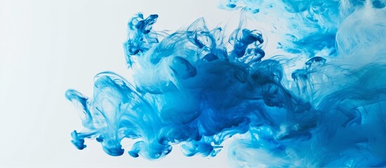 Blue ink droplets in water can create a smoky texture, against a partly white backdrop.