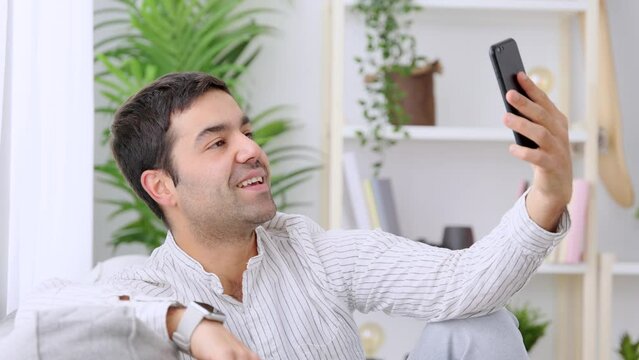 Closeup of man having video call. Hispanic person talking on phone at home.
