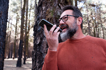 One man using phone cellular connection in a forest wood enjoying technology and outdoor leisure...