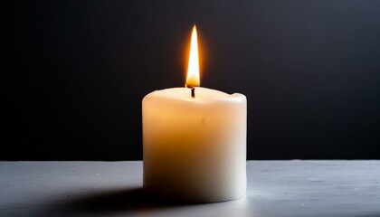 Fototapeta na wymiar White burning candle on a black background 