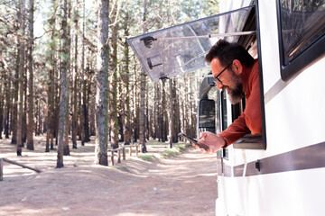 One man enjoying the view outside the window of a motorhome camper van enjoying vanlife and...
