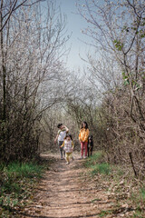 three children running on the country road with their dog