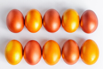 Shiny golden Easter eggs close-up on a white background.