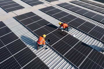 Engineering technician professional trained in skills and techniques installing solar photovoltaic panels system, engineer service check installation solar cell on factory roof, technology solar cell © AU USAnakul