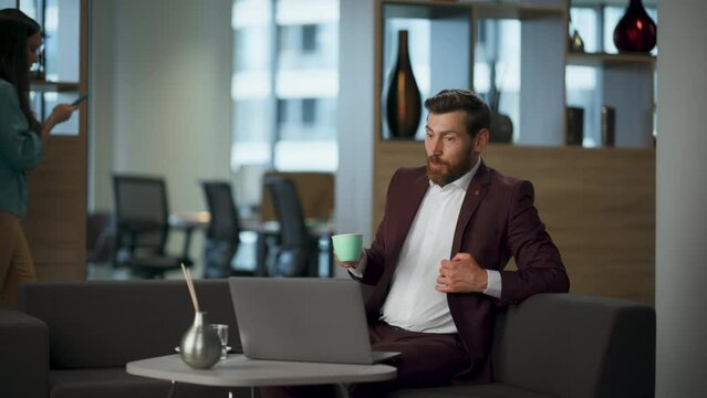 Surprised man staring computer screen coworking interior. Businessman rejoicing