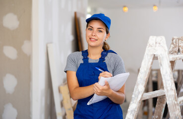 Woman foreman checks the completed construction work on the drawing