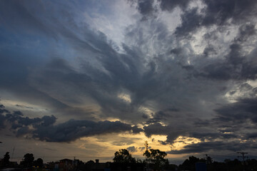 Sunset in the city, dramatic sky with clouds and silhouette of trees