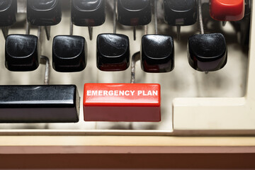 Text of 'Emergency plan' on a vintage typewriter button