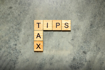 The row of wooden cubes with 'Tips tax' text