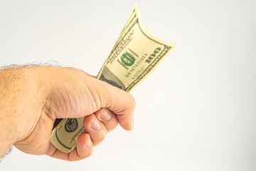 Hand holding money isolated on white background. One hundred Dollars bill on man hand to paying and giving.