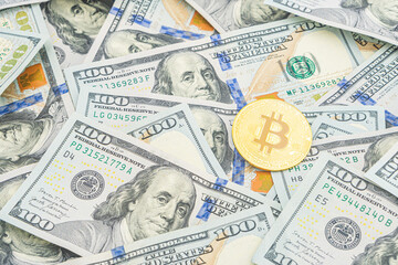 Gold Bitcoin on hundred dollars bills. Golden symbolic coin Bitcoin on banknotes of one hundred dollars. Cryptocurrency on US dollar bills. Digital modern method of payment. Exchange bitcoin cash