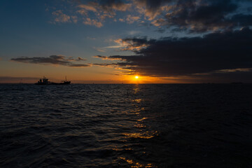 広がる海と雲に入る前の朝日と20240108