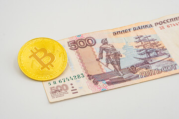 bitcoin cryptocurrency with russian rubles money, five hundred banknotes closeup. Cryptocurrencies bitcoin in russia. Bitcoin and Russian money.