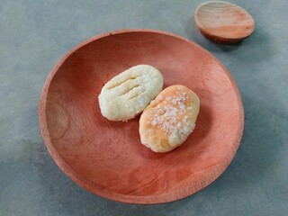 Cookies sprinkled with granulated sugar served on a wooden plate. bakpia. small dry bread topped with granulated sugar. tea time.