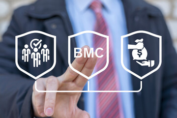 Businessman using virtual touch screen presses abbreviation: BMC. Business Model Canvas ( BMC )...