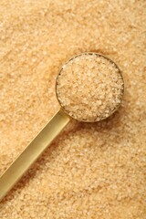 Scoop on granulated brown sugar, above view