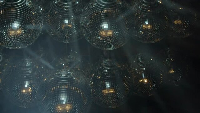 Mirror balls reflect bright light, fog creates moving light beams