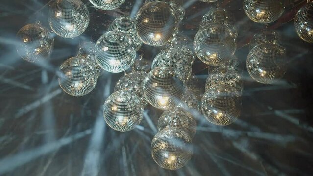 Hazy laser light show with mirror disco balls in foggy darkness