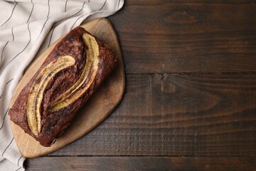 Delicious banana bread on wooden table, top view. Space for text