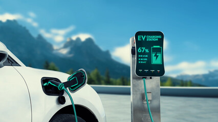 Electric car plugged in with charging station to recharge battery by EV charger cable with nature...