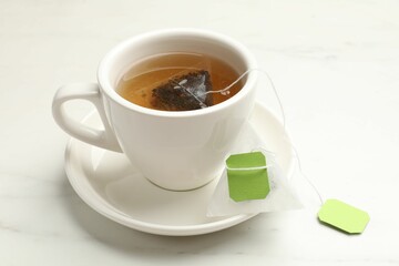Tea bag in cup on white table, closeup