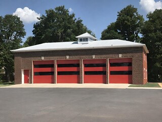 Fire station with four bright red garage doors. Generative AI.