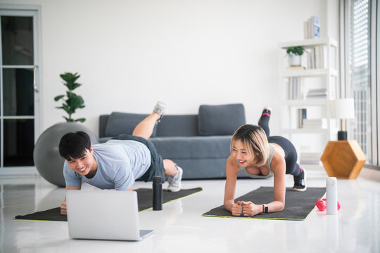 Couple Practicing Stretching Exercise At Home