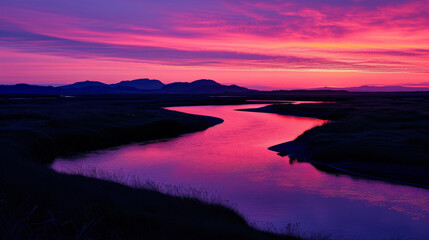 A winding river is silhouetted against a bright and colorful sunrise sky creating a serene and peaceful image.