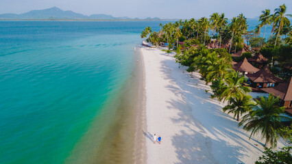 Naklejka premium Koh Mook Drone view at a couple walking on the white sandy tropical beach of Koh MukThailand