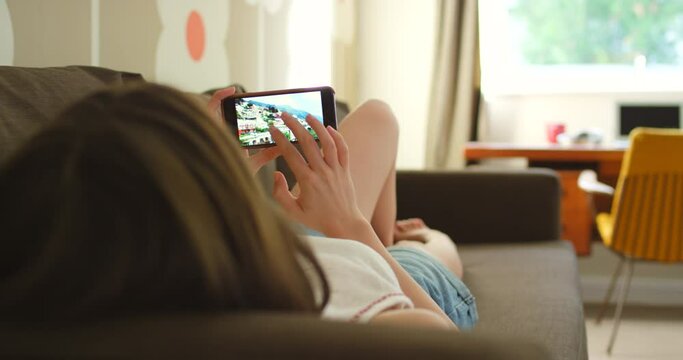 Phone, screen and woman looking at pictures for social media or internet in living room at home. Rest, photography and female person swipe images on cellphone relaxing on sofa in apartment or mobile