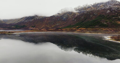 Mystic Mornings in Lofoten: Fog-Enshrouded Peaks and Mirror-Like Lake