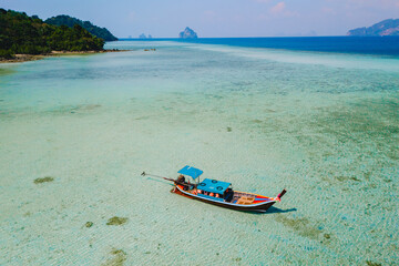 longtail boat in the turqouse colored ocean with clear water at Koh Kradan Thailand
