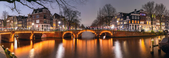 Fototapeta na wymiar Panorama of typical houses and bridge at Amsterdam canal Brouwersgracht at night, Holland, Netherlands