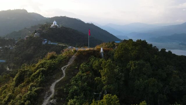 Flying Towards Mountain Viewpoint In Pokhara, Nepal With View Of World Peace Pagoda In Distance. aerial shot