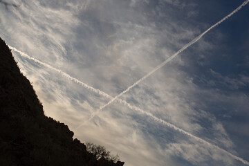 Two aircraft contrails cross in the sky