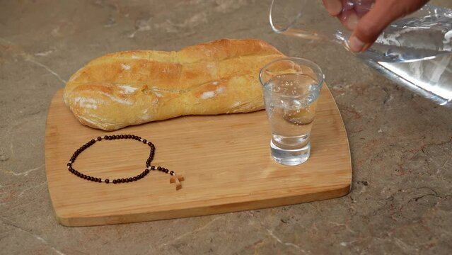 llenando vaso con agua para ayuno en cuaresma religi&oacute;n sacrificio oraci&oacute;n y espiritualidad