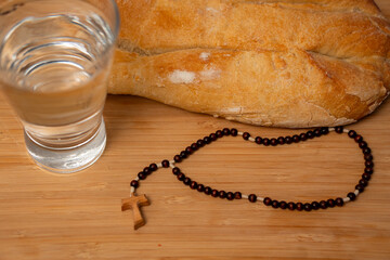 acercamiento de pan y agua y rosario listos para el ayuno para ayunar en cuaresma signos religiosos católicos sacrificio y oración