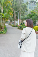 Fototapeta na wymiar 台湾台北市士林区の大きな公園で２０代の若い台湾人女性が散歩する風景 A young Taiwanese woman in her 20s taking a walk in a big park in Shilin District, Taipei City, Taiwan