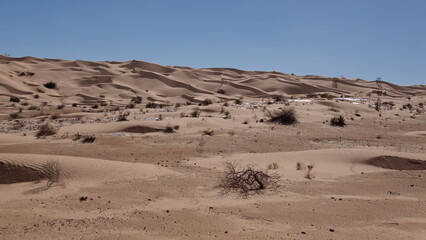 Fototapeta na wymiar Valley surrounded by tall sand dunes in the Sahara Desert, outside of Douz, Tunisia