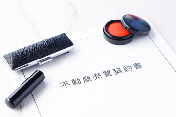 不動産を売買する契約の際に交わす不動産売買契約書と印鑑、朱肉
