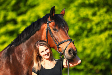 Obraz premium Horse and girl head portraits against a green background in the sunshine