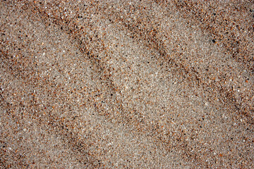 Waves on the surface of the sand, top view. The wavy surface of coastal sand. The structure of waves on sea sand.