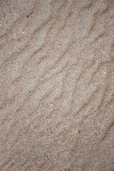 Waves on the surface of the sand, top view. The wavy surface of coastal sand. The structure of waves on sea sand.