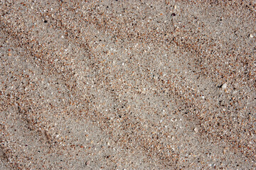 Waves on the surface of the sand, top view. The wavy surface of coastal sand. The structure of waves on sea sand.